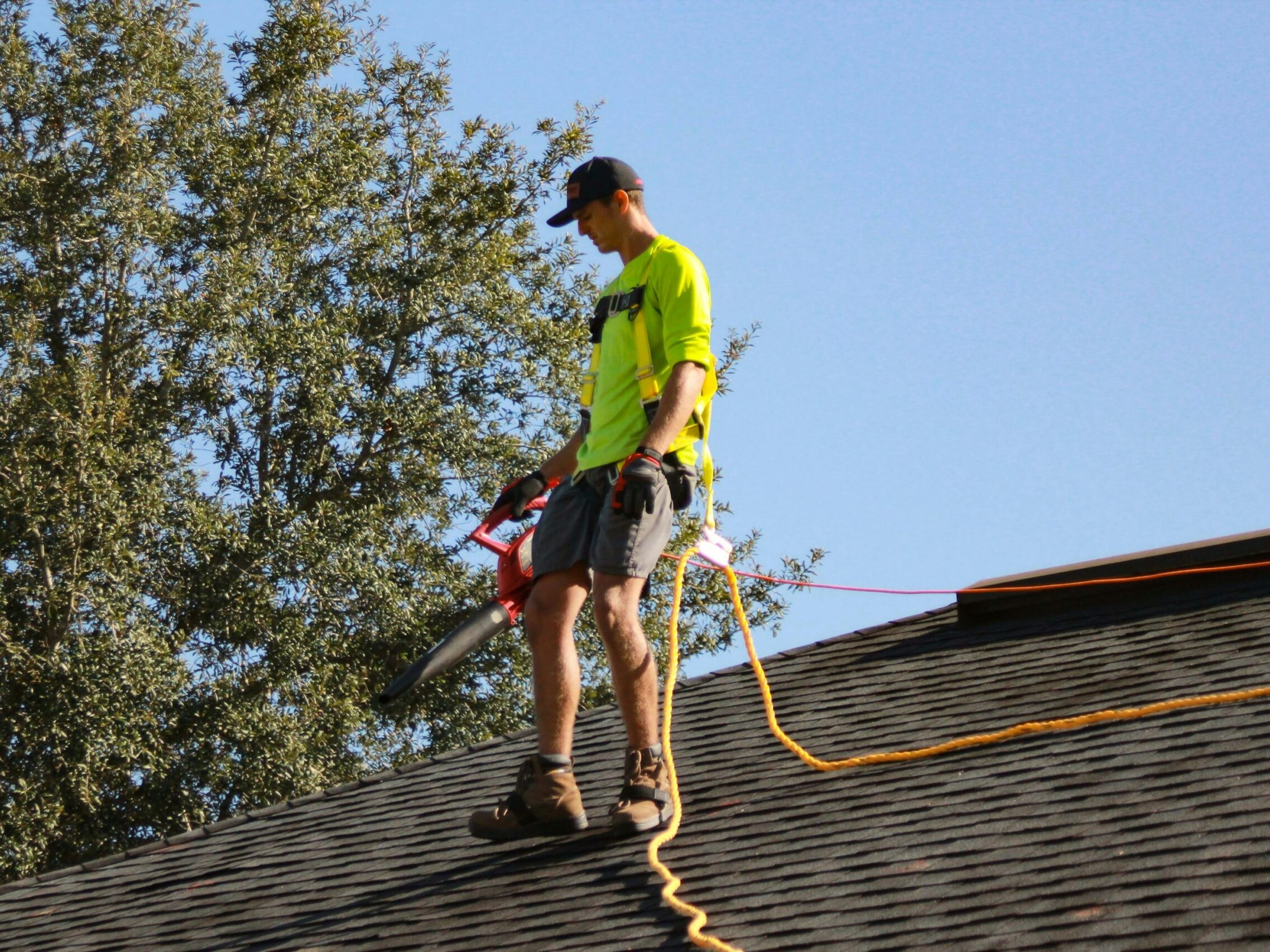 Irish Shine technician safely cleaning a roof with professional equipment